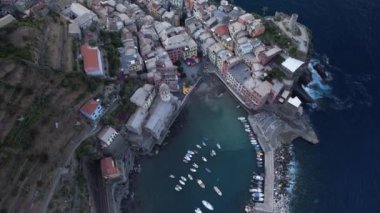 Alacakaranlık köyü sararken Vernazza 'nın sakin bir manzarası. Limanda renkli binaların çarpıcı zeminine karşı tekneler yavaşça sallanıyor..