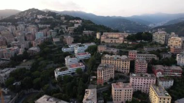 Güneş tepenin ardında batarken, Genova 'nın nefes kesici panoramik manzarasını tecrübe edin. Canlı mimariyi ve bereketli manzaraları vurguluyor..