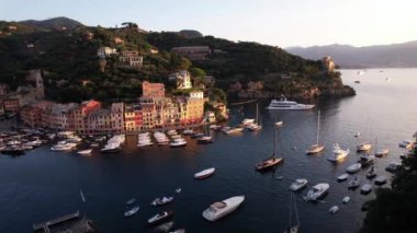 Altın ışınlar köyü aydınlatırken Portofino 'nun cazibesini keşfedin ve günbatımında sakin limanda sallanan tekneler.
