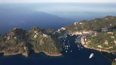 Güneş Akdeniz 'in üzerinde batarken Portofino' nun nefes kesici güzelliğini keşfedin. Canlı evleri ve sakin suları aydınlatın..