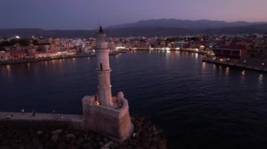 Chania 'nın tarihi deniz fenerinin üzerindeki alacakaranlığın dinginliğini hisset. Gecenin başlangıcındaki gökyüzünün altında parıldayan canlı liman Girit' in güzelliğini yakalıyor..