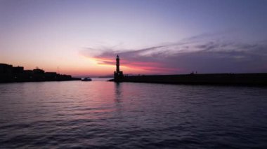 Alacakaranlık renklerinin sakin sulara yansımasına tanık olun. Chania, Girit 'teki deniz feneri gururla duruyor. Huzurlu anlar için mükemmel bir zemin oluşturuyor..