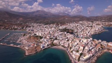 Yunanistan 'ın Girit kentindeki güzel Agios Nikolaos kasabasını keşfedin, açık gökyüzü altında canlı marina, büyüleyici binalar ve nefes kesici kıyı manzaralarını sergileyin..