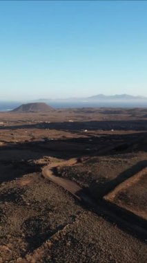 Güneş doğarken Fuerteventura 'nın engebeli engebeli arazisine tanık olun. Manzara üzerinde güzel, ılık renkler yaratıyor..