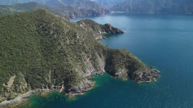 Korsika 'nın nefes kesen kıyılarını keşfedin. Güneşin altında berrak mavi sularını ve dramatik uçurumlarını sergileyin..