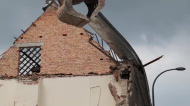 Eski bir yapının kalıntılarını kazan büyük bir makine enkaz düşerken tuğla ve kirişleri ortaya çıkarıyor..