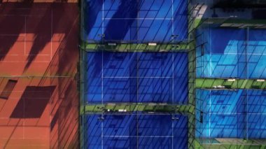 Tenis kortlarının çarpıcı desenlerini ve renklerini keşfedin öğleden sonra güneşi ilginç gölgeler oluştururken yukarıdan yakalanan.