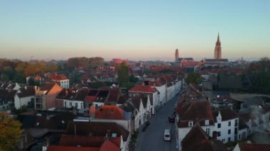 Brugge 'ün güzelliğini hissedin. Şafağın ilk ışıkları büyüleyici çatılara ve tarihi yapılara sıcak bir ışık saçıyor..