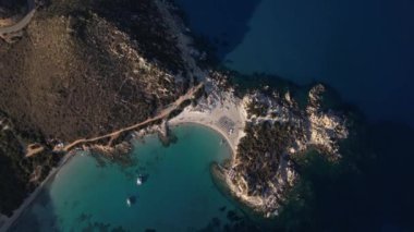 Güneş batarken Punta Molentis 'in nefes kesici kıyı şeridini keşfedin, sakin suların üzerine canlı renkler saçın..