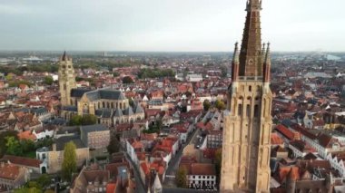 Brugge 'ün ikonik kuleleri ve ortaçağ binaları karanlık çökmek üzereyken nefes kesen ufuk çizgisini keşfedin..