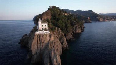 Portofino deniz fenerinin güzelliğini hissedin. Güneş resim gibi sahil şeridinde batarken..