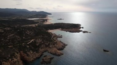 Sardunya 'nın nefes kesici kıyı manzaralarını deneyin. Sabahın erken saatleri sakin sularda dans ediyor..