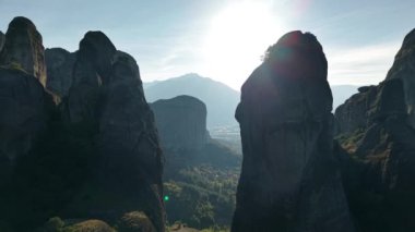 Güneş görkemli kaya oluşumlarının üzerinde yükselirken, Yunanistan 'daki meteorun büyüleyici güzelliğini deneyimleyin, manzarayı aydınlatın.