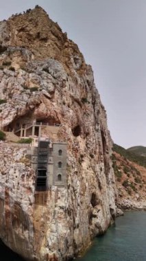 Sardinya 'daki Porto Flavia' nın nefes kesici uçurumlarını keşfedin. Tarihi mimari ve doğal güzellikleri sergileyin..