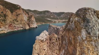 Sardunya 'da sakin bir yaz gününde Porto Flavia' nın nefes kesici uçurumlarına ve berrak sularına tanık olun..