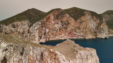 Sardunya 'daki Porto Flavia' yı çevreleyen nefes kesici uçurumlara ve turkuaz sulara hayran olun. Bu kıyı manzarasının dingin güzelliğini hissedin..