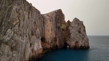 Sardinya 'daki Porto Flavia' nın nefes kesici uçurumlarını deneyin. Güneş sakin suların üzerinde batarken..