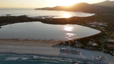 Alacakaranlıkta sakin sulara ve Sardunya sahillerine yansıyan nefes kesici günbatımına tanık olun..