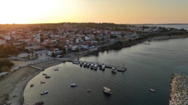 Güneş batarken Halkidiki 'nin sihrini tecrübe edin. Garip evler ve güzel bir liman. Yelkenliler akşam gökyüzünün altın renklerini yansıtarak nazikçe suda sallanırlar..