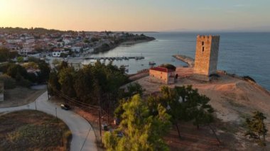 Alacakaranlıkta Halkidiki 'nin büyüleyici güzelliğini tecrübe edin. Gök mavisi suların tarihi simgeler ve sakin manzaralarla buluştuğu yerde. Batan güneşin ışıltısı Sahilde altın bir renk bırakıyor.