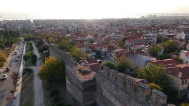 Güneş batarken Selanik 'in büyüleyici siluetine tanık olun. Şehrin tarihi duvarlarını ve büyüleyici çatılarını aydınlatıyor..