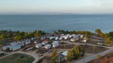 Halkidiki 'nin sakin kıyıları boyunca uzanan bu manzaralı kaçış, yemyeşil kulübelerle çevrili büyüleyici kulübeleri gözler önüne seriyor. Yumuşak dalgalar ve huzurlu görüntüler büyüleyici bir atmosfer yaratır..