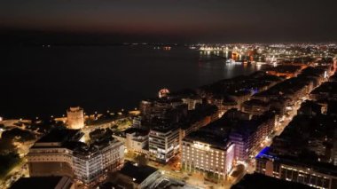 Bu büyüleyici manzara Selaniklilerin hareketli caddeleri ve parıldayan kıyı şeridini gözler önüne seriyor. Parlak şehir ışıkları denizi yansıtıyor, pitoresk bir atmosfer yaratıyor..