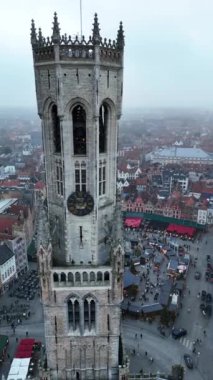 Bruges 'ün sisle kaplanmış büyüleyici atmosferini tecrübe edin. Görkemli çan kulesi hareketli Noel pazarından yükselirken şehrin şenlikli ruhunu yansıtıyor..
