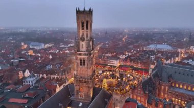 Akşamları Noel pazarı canlanırken Bruges 'ün büyüleyici atmosferini keşfedin. Parlayan ışıklar tarihi binaları aydınlatıyor ve meydanı şenlikli dekorasyonlar dolduruyor..