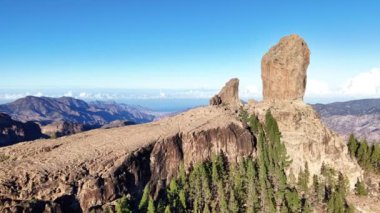 Gran Canaria 'da Roque Nublo' yu araştırmak engebeli arazi ve yemyeşil manzaraların nefes kesici manzaralarını ortaya çıkarıyor. İkonik kaya oluşumu açık mavi gökyüzüne çarpıcı bir şekilde yükselir..