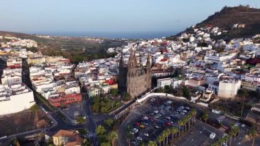 Arukas Gran Canaria 'nın cazibesini keşfedin çünkü panoramik görüntüler yemyeşil ve kıyı manzaralarının ortasındaki güzel mimariyi gözler önüne seriyor. Doğanın ve şehir hayatının çarpıcı zıtlığının tadını çıkar..