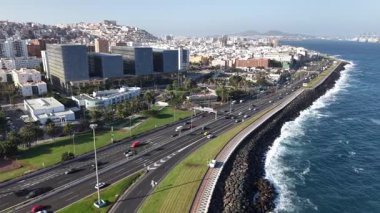 Las Palmas de Gran Canaria 'da canlı bir sahil yolculuğu yaşayın. Güzel bir kıyı şeridi, büyüleyici şehir mimarisi ve gezinti güvertesi boyunca hareketli bir trafik..