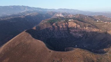 Gran Canaria 'daki volkan kraterinin nefes kesen manzarasına tanık olun, engebeli arazisini ve güneş güzel bir şekilde batarken etrafındaki canlı manzarayı gösteriyor..