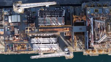 Su kenarında geniş bir boru, makine ve ekipmanların yer aldığı, modern sanayinin detaylı mimari ve mühendislik harikalarını gözler önüne seren geniş bir endüstriyel tesisin çok üzerinde..