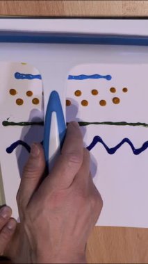 Bu ilgi çekici aktivite renkli scrabble resim tekniklerini bir tuval üzerinde canlı renkler olarak vurguluyor. Parlak bir stüdyo ortamında yaratıcılığın gelişini izleyin..