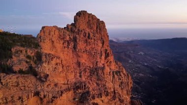 Gran Canaria 'nın etkileyici hava manzarası dramatik uçurumları ve sakin kıyı şeridini gösteriyor. Gün batımının ılık ışığı bu resmedilmiş adanın doğal güzelliğini vurgular..