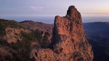 Güneş ufukta batarken engebeli dağlarını ve çarpıcı sahil şeridini gösteren Gran Canaria 'nın nefes kesici hava manzarası. Doğanın güzelliği bu olağanüstü manzarada ortaya çıkar..