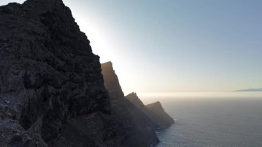 Gün batımında Gran Canaria 'daki Tamadaba doğal parkının nefes kesici hava perspektiflerini tecrübe edin. Bu çarpıcı manzarada okyanusa kavuşan engebeli kayalıklara bakın..