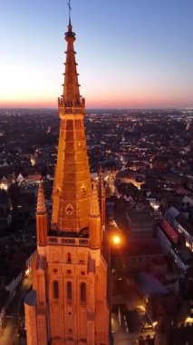 Belçika 'nın Brugge kentinin nefes kesici hava manzaraları ikonik mimarisini ve büyüleyici kanallarını vurguluyor. Güneş tarihi ufkun üzerinde batıyor, büyülü bir atmosfer yaratıyor..