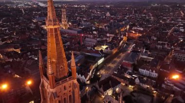 Belçika 'nın Brugge kentinin ikonik ortaçağ binalarını ve sakin kanallarını aydınlatan nefes kesici hava manzarasını araştırın. Alacakaranlık çöktüğünde şehir güzelce parlıyor, cazibesini açığa vuruyor..