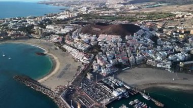 Tenerife 'deki Los Cristianos' un büyüleyici sahil manzaralarını keşfedin. Canlı bir marina, kumlu plajlar ve çevreleyen tepeler..