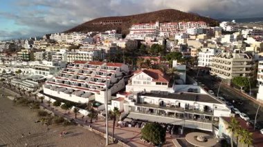 Los Cristianos, Tenerife 'nin güzel sahil şeridini keşfedin, büyüleyici binaların sahille buluştuğu yeri. Bu popüler yerdeki canlı atmosfere ve çarpıcı manzaralara tanık olun..