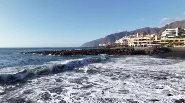 Yüksek uçurumlar ve mavi sularla Tenerife Los Gigantes 'in nefes kesici kıyı manzarasını deneyin. Dalgalar kayalara çarpar ve bu manzaranın doğal ihtişamını gösterir..