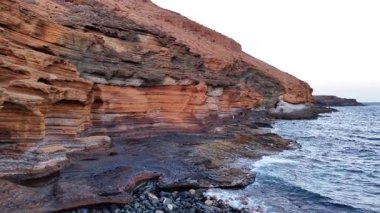 Renkli uçurumları ve kayalık kıyı şeridiyle Tenerifes 'in nefes kesici hava manzarasını deneyin. Altın saat, manzaranın üzerine ılık bir ışık saçıyor..