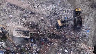 Görüntü, bir atık yönetim tesisinde atık işlemekte olan ağır makineleri yakalıyor. Atık materyallerini etkili bir şekilde sınıflandırmak ve yönetmek için çeşitli işlemler yürütülür.