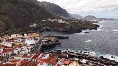 Tenerife 'nin nefes kesici sahil şeridini, canlı kasabayı ve kıyı boyunca uzanan bereketli dağlık araziyi görüntüleyen havadan bir perspektifini deneyimleyin. Bu inanılmaz adanın doğal güzelliğini keşfedin..