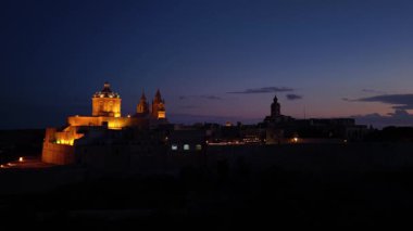 Sıcak ışıkların tarihi mimariyi aydınlattığı Mdina, Malta 'daki büyüleyici alacakaranlığı deneyimleyin. Antik şehir, cazibesini gece çökerken sergiliyor..