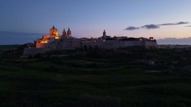 Alacakaranlıkta Malta, Mdina 'nın güzelliğini keşfedin. Gece çöktüğünde, şehir, eski binalarını ve büyüleyici çevresini aydınlatan sıcak ışıklarla dönüşüyor..
