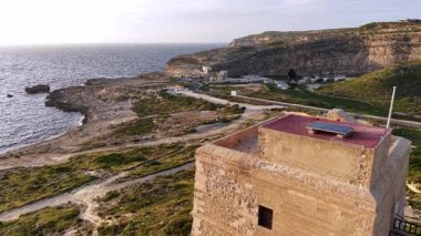 Maltas engebeli kıyı şeridinin çarpıcı hava manzaralarını deneyin, güzel akşam parlaması sırasında antik yapılar ve sakin suların yer aldığı. Doğal güzelliği ve mirası keşfedin..