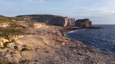 Güneş kıyı şeridinde batarken Malta 'nın doğal güzelliğini keşfedin. Denizden yükselen görkemli kayalıklar, açık havada keşif ve rahatlama için mükemmel bir zemin oluşturuyor..